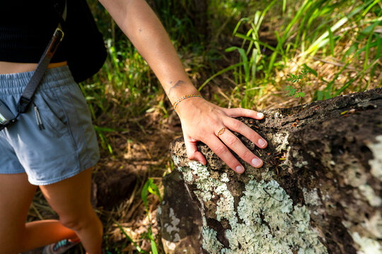 hiker touching rock 