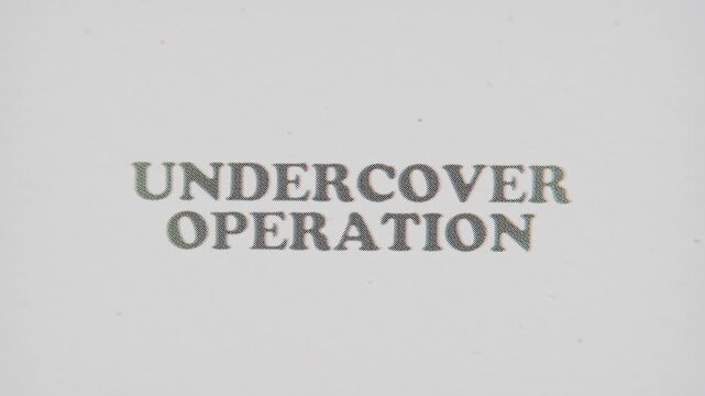 CMYK Halftone Text Undercover Operation Printed on Changing Paper with Vintage Stop Motion Effect.
