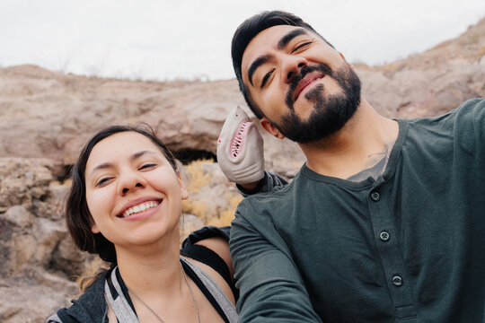 Funny couple taking a selfie with a shark puppet