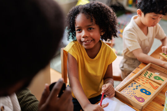 Children learning math with teacher in classroom.