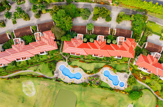 Aerial view of hotel with two swimming pools and greenery
