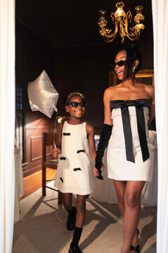 Mother and Daughter Walking in Matching Outfits During a Celebration