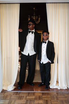 Stylish Men Pose in Formal Wear Inside a Well-Lit Room