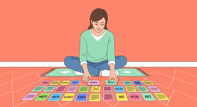 Woman sorting educational flashcards with school subjects on the floor