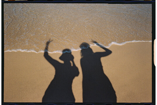 portrait of two friends beach shadow