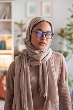 Portrait of a woman wearing a hijab and glasses.