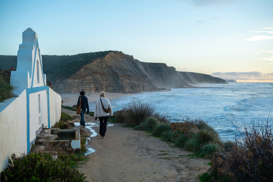 Two women on a beach walk by Atlantic Ocean