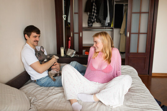 A young couple with a dog spend time in an apartment