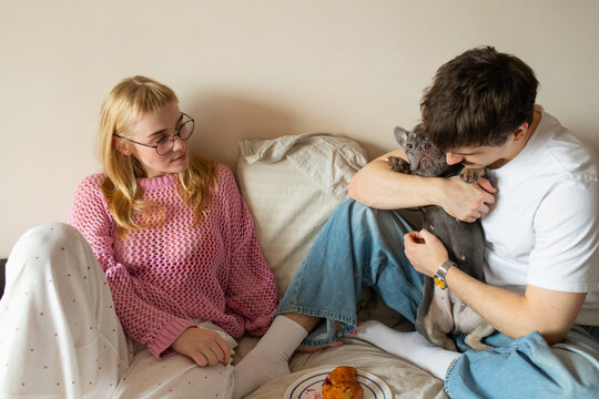 A young couple with a dog spend time in an apartment