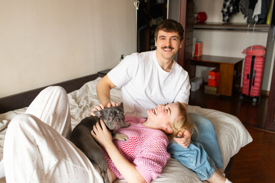 A young couple with a dog spend time in an apartment