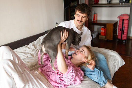 A young couple with a dog spend time in an apartment