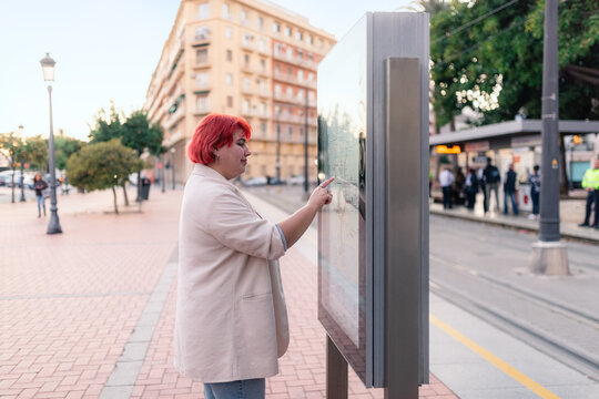 Woman Looking at Map in City Street During Evening