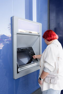 Woman using ATM in the city 