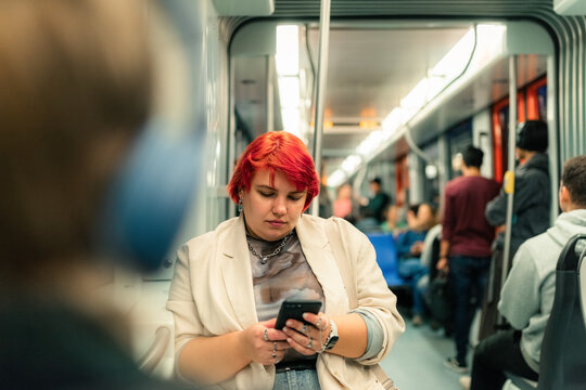 Passenger using smartphone in subway train 
