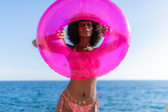 Model posing with pink swim ring 