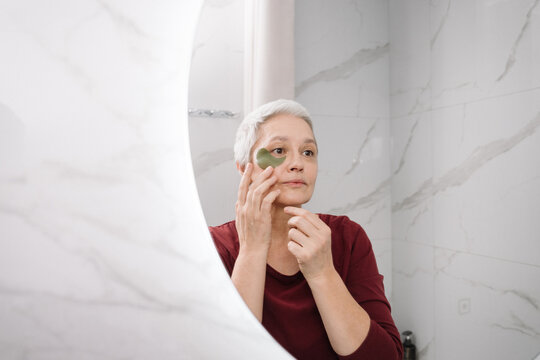 A woman applies eye patches