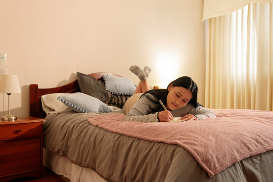 Woman Journaling in Bedroom During Quiet Moment