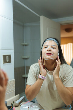 Woman Checking Sheet Mask Fit at Bathroom Sink