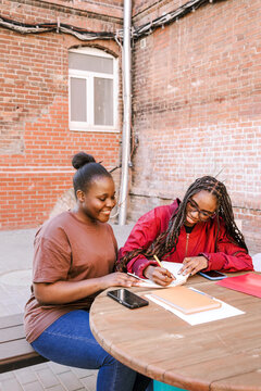 Two friends study and smile together.