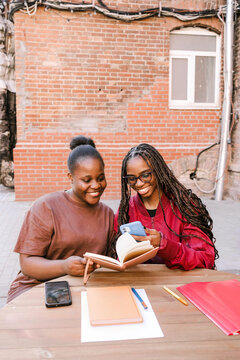 Two friends study and smile together.