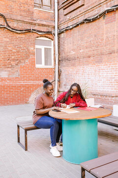 Two friends study and smile together.