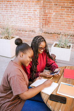 Two friends study and smile together.