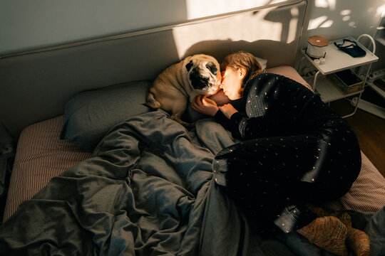 Woman and Dog Spend Morning on the Bed in Warm Light