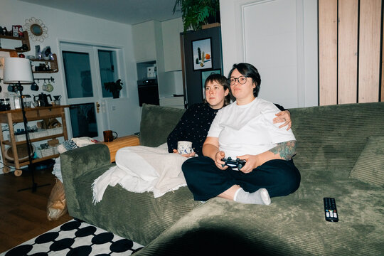 Couple is Playing Video Games in a Cozy Living Room at Night