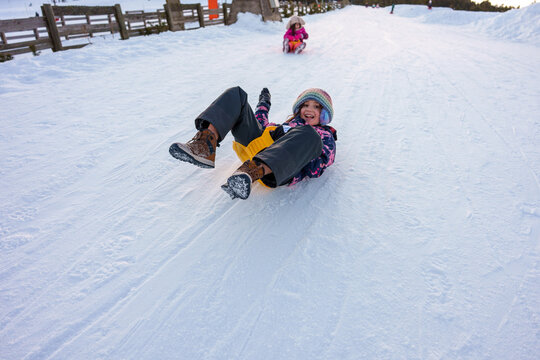 Kids Enjoy Sledding on a Snowy Hill al winter. France