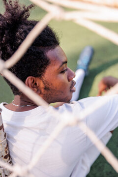 Soccer player rests behind the net
