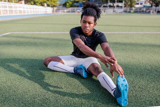 Young Black rugby player stretches on field