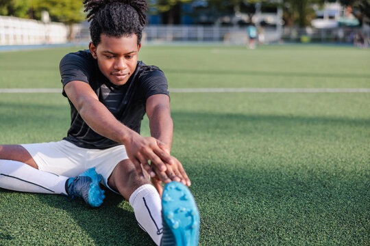 Soccer player stretches before practice
