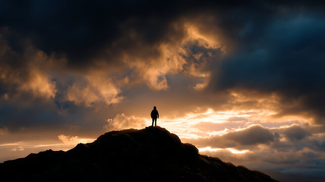 Silhouette of a person on a mountaintop, dramatic sky with clouds and golden light, epic style, high resolution