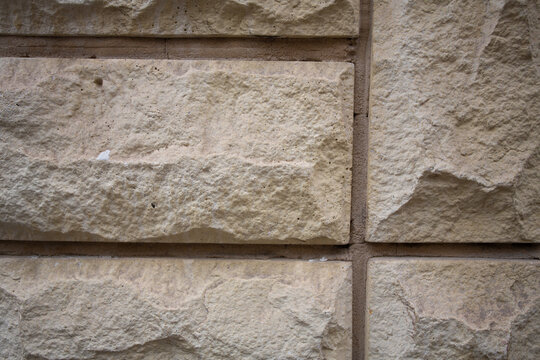 Mur beige en pierres de taille en relief