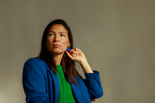 Woman in Blue Jacket Posing With Green Top Indoors