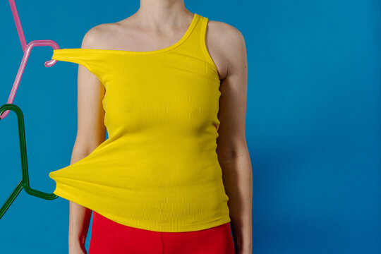 Conceptual Fashion Shot With Yellow Top Pulled by Plastic Hanger