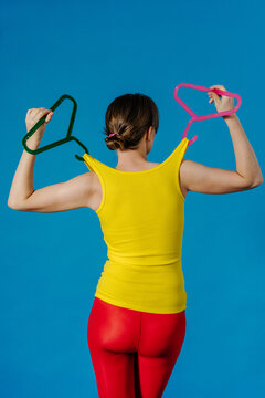 Back View Fashion Concept With Yellow Top Pulled by Color Hangers
