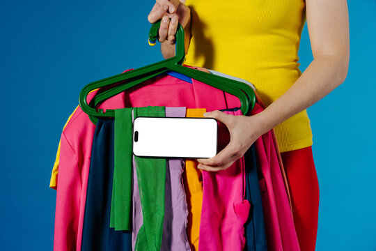 Colorful Clothes on Hangers With Smartphone Mockup on Blue Background
