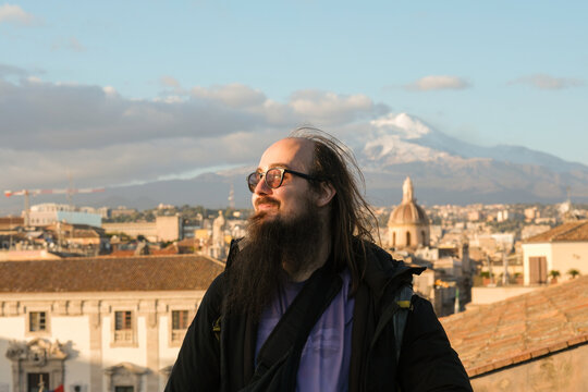 Bearded Man Looking Over City Skyline at Sunset