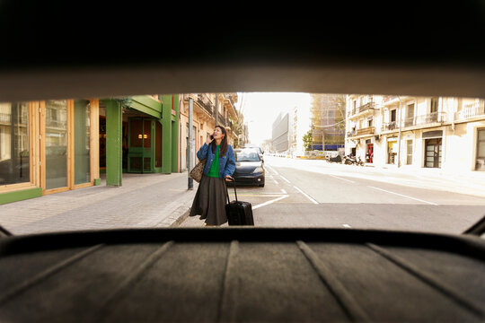Woman Waiting on Street With Suitcase in City Scene