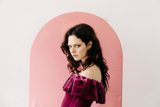 Woman with pink arched background