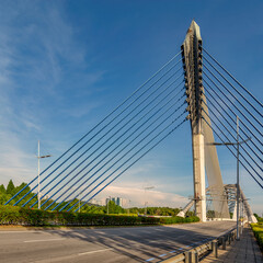 Obraz premium Seri Wawasan Bridge, a modern cable-stayed bridge in Putrajaya, Malaysia, featuring its distinctive pylon and blue cables against a clear blue sky on a sunny day