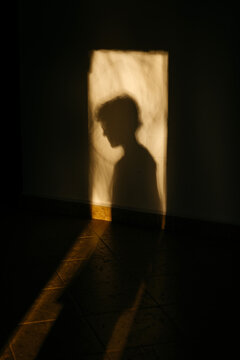 Person silhouette cast on interior wall