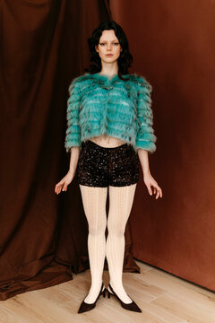 Woman in teal cropped faux fur jacket