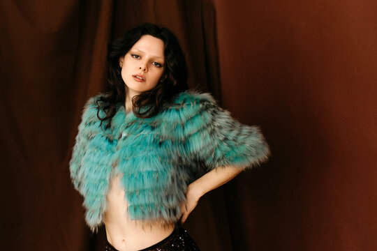 Woman posing in stylish turquoise fur coat