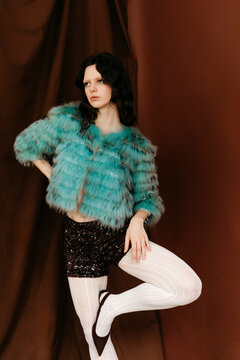 Woman in turquoise fur coat and sequin shorts