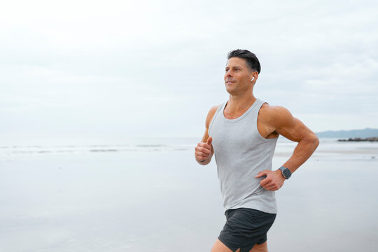 Man runs along a beach in morning
