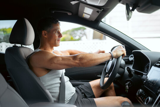 Man driving a car during the day
