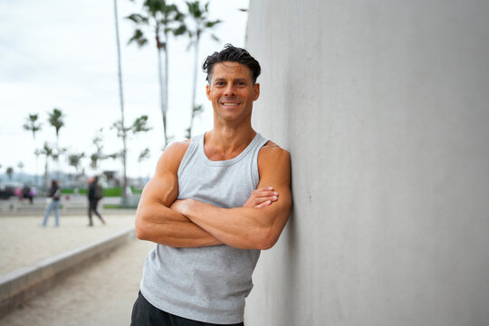 Man poses by wall at beach
