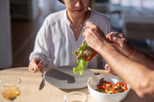 Salad being served to a woman at the table.